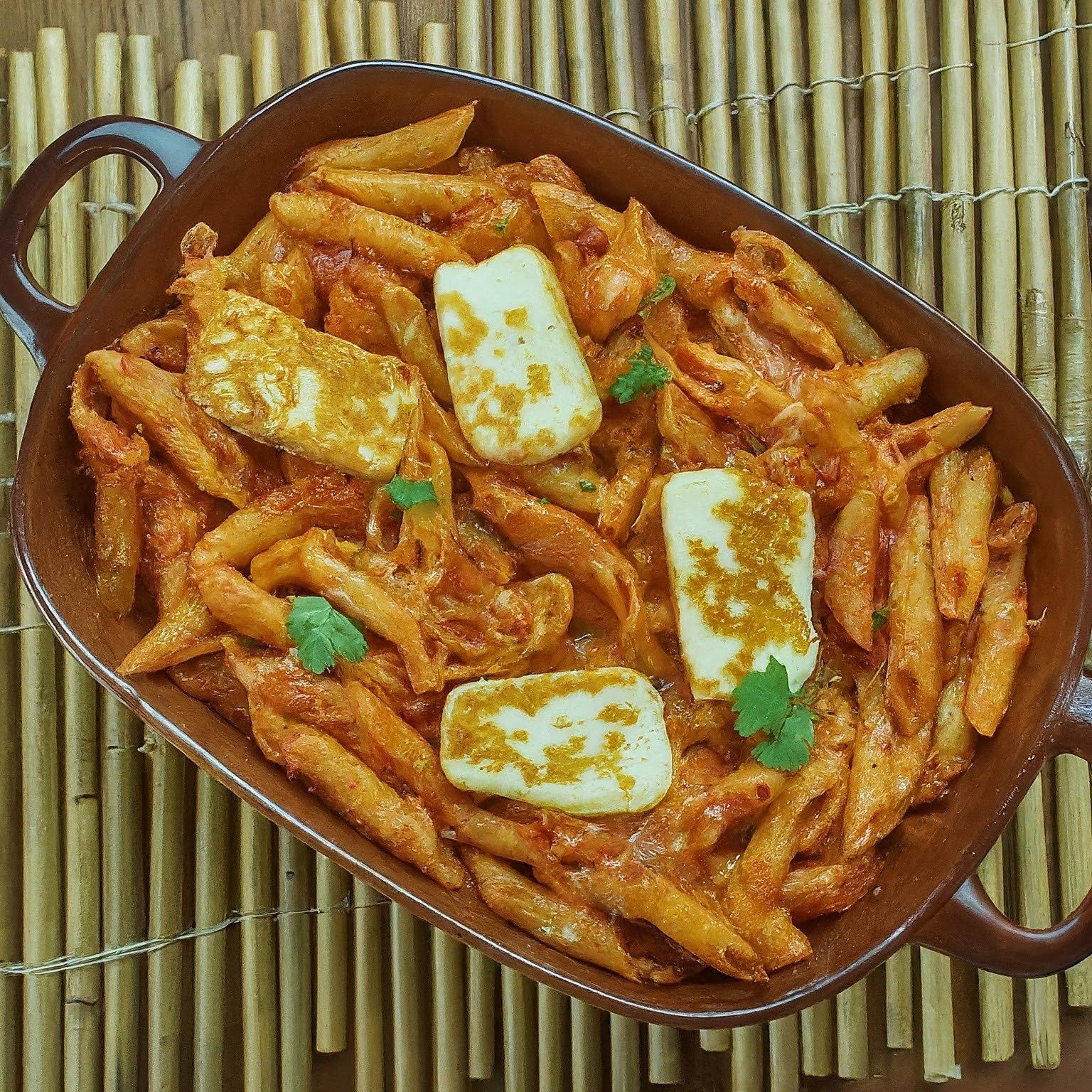 Baked Tomato Pasta With Harissa and Halloumi